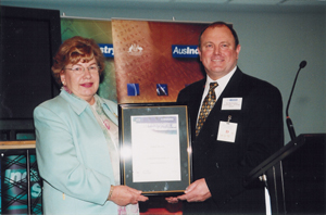 Nik Fominas receiving AusIndustry Certificate of Achievement for Business Excellence from Senator Margaret Reid